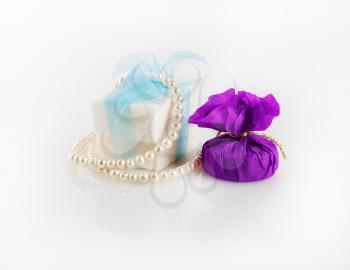 Conceptual festive still life. Gift box, soap and a pearl necklace.