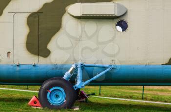 A fragment of the old heavy truck military helicopter close-up. Landing gear of an helicopter on the green grass.