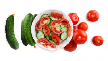Sliced tomatoes and cucumbers and white plate. Clipping path.