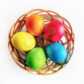 Colorful easter eggs. Easter eggs in a wicker basket. Top view.