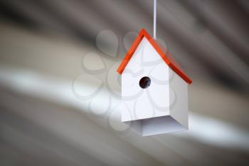 Lamp in the form of a white birdhouse with a red roof in the interior. Shallow depth of field. Selective focus.