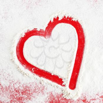 Abstract red heart on a background of white flour. Painted heart.