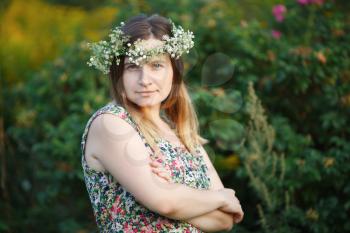 Pretty young woman with wreath on head. Sunset light. Shallow depth of field. Focus on model.