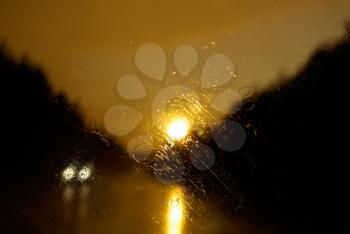 Drops of rain on the windscreen of the car. Sunset.