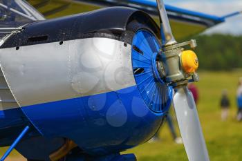 Engine and propeller of blue airplane. Close-up of a single-engine plane fuselage. Fragment of the aircraft.