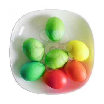 Colored Easter eggs on white plate. Isolated with clipping path on white background. Top view.