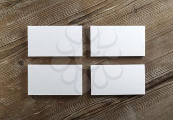 Blank cardboard business cards on a dark wooden table. Template for ID. Top view.