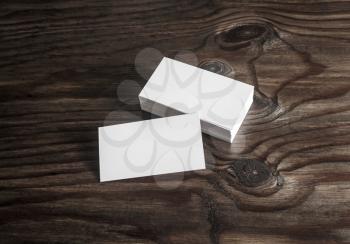 Blank business cards on dark wooden background. Mock-up for branding identity. 
