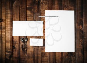 Blank stationery set on vintage wooden table background. ID template. Mockup for branding identity for designers. Blank letterhead, business card, envelope and pen. Top view.