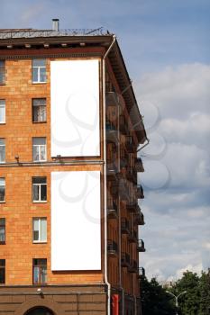 Two blank vertical billboards on the wall of a brick house. Clipping path.