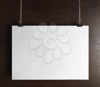 Blank poster hanging on wooden background. Front view.