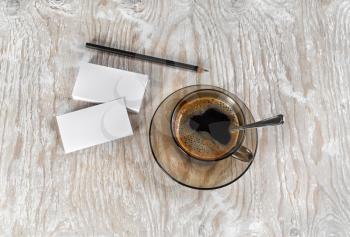 A cup of coffee, business cards and a pencil on a background of a wooden table. Top view.