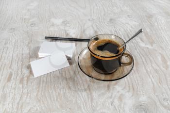 Photo. Cup of coffee, blank business cards and a pencil on a background of a wooden table.