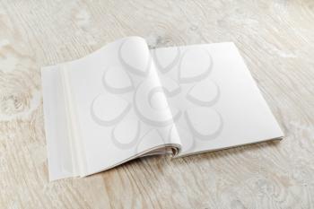 Photo of bank opened booklet on light wooden background with soft shadows. For design presentations and portfolios.