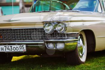 MINSK, BELARUS - MAY 07, 2016: Close-up photo of beige Cadillac de Ville 1959 model year. Headlight of vintage car. Close-up detail of retro auto. Selective focus.