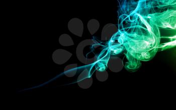 Abstract bright colored green and blue smoke on a dark background.