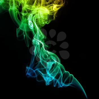 Colorful yellow and green smoke on a dark background.