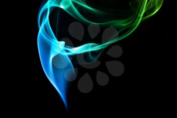 Abstract blue and green smoke on a dark background.