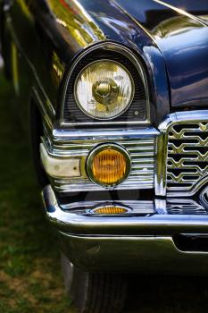 MINSK, BELARUS - MAY 07, 2016: Chaika GAZ-13 - Soviet car. Close-up of the headlights and the front part of an old black vintage retro auto Chaika GAZ-13. Selective focus on the car's headlight.