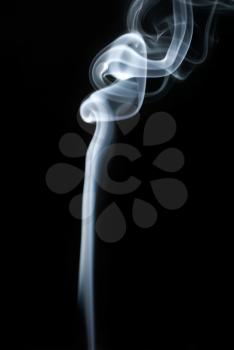 Abstract smoke swirls on black background. Vertical shot.