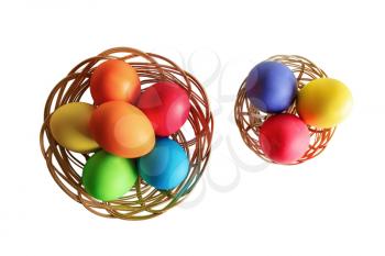 Easter eggs in two wicker baskets. White background. Top view.