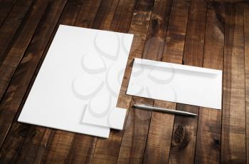Photo of blank stationery set on wooden table background. Blank letterhead, business cards, envelope and pen. Mock up for branding identity. ID template.