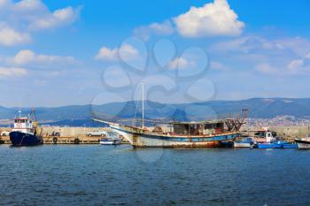 Nesebar, Bulgaria - August 30, 2013: Old ship, boats, yachts and launches, standing at the pier in the port of the old town of Nessebar, on the Black Sea coast. Sunny summer day.