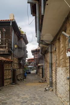 Nesebar, Bulgaria - September 08, 2014: Narrow street with old houses in the seaside resort and ancient old town Nessebar in Bulgaria. UNESCO world heritage site. Vertical shot.
