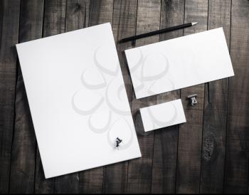 Blank stationery set with plenty of copy space for placing your design. Blank letterhead, business cards, envelope and pencil. Corporate identity mockup on vintage wooden table background.
