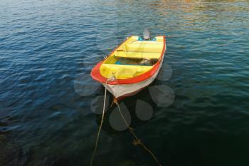Old yellow with red fishing boat on the background of a calm sea water. Motor boat at the pier. Rowboat on the water.