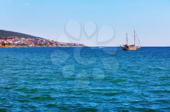 Picturesque seascape. Black Sea coast. Pleasure yacht and shore on the horizon.