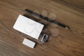Photo of blank business cards, pencil, eraser and sharpener on wooden table background. Mock up for ID. Blank template for branding identity for designers. Top view.