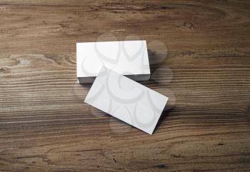 Photo of blank business cards on a wooden table background. Template for ID.