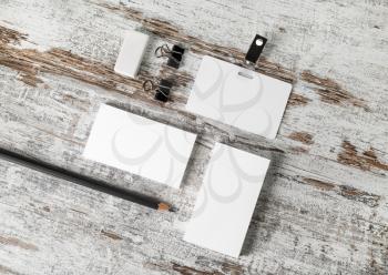 Photo of blank stationery set. Business cards, badge, pencil and eraser on vintage wood table background. Blank branding template.