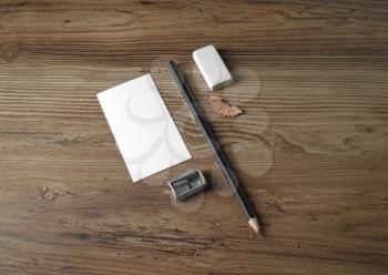 Business card, pencil, eraser and sharpener on wooden table background. Bank stationery set. Top view.