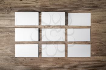 Many blank business cards on wood table background. Blank paperwork template for placing your design. Mockup for ID. Top view.