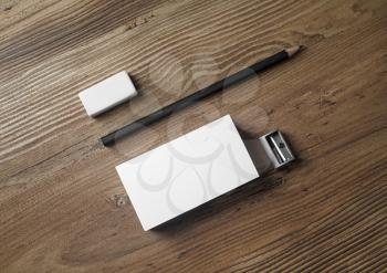Photo of blank business cards, pencil, eraser and sharpener on wood table background. Mockup for ID. Blank template for placing your design. Top view.