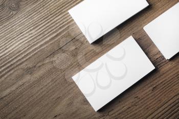 Photo of blank business cards on wood table background. Template for ID. Mock up for branding identity. Top view.