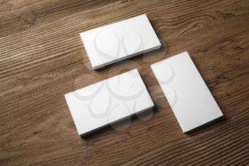 Photo of blank business cards on wooden background. Template for ID. Responsive design mockup.