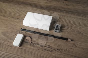 Blank stationery elements. Business cards, pencil, eraser and sharpener on wooden table background. Responsive design mockup.