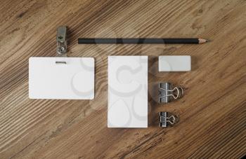 Blank branding template on wooden table background. Bank business card, badge, pencil and eraser. Stationery and ID mock up. Top view.