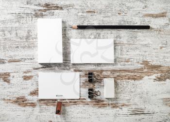 Photo of blank stationery. Business cards, badge, pencil and eraser on vintage wood table background. Responsive design mockup. Top view.