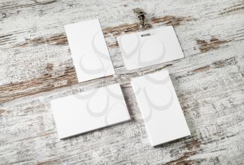 Photo of blank business cards and badge on vintage wood table background. Responsive design mockup. Top view.