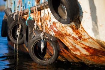Nesebar, Bulgaria - September 10, 2014: Old tires on ship. Used for impact protection of a ship. Selective focus.