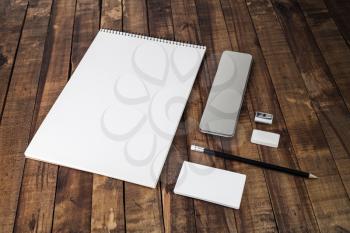 Photo of blank stationery set on wood table background. Blank template with plenty of copy space for designers. Responsive design mockup.