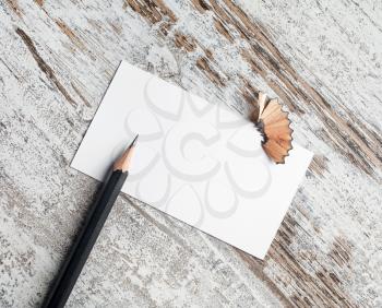 Photo of blank business card and pencil on vintage wood table background. Blank stationery template for placing your design.