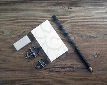 Blank business cards, pencil and eraser on wooden background. Mockup for ID. Template for branding identity. Top view.