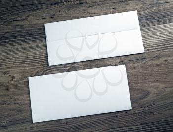 Two white blank envelopes on wooden background. Front and back side.