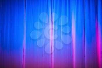 Bright blue stage curtain with spotlight. Abstract background.