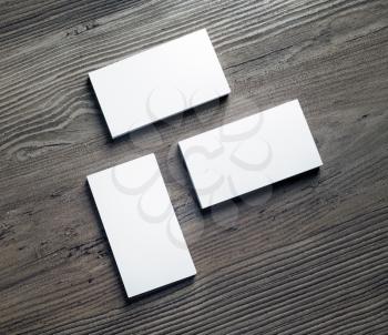 Three piles of blank business cards on wood background. Template for your design. Top view.